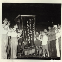1958年12月演出结束后，清华大学文工团成员接受政协全国委员会赠送的锦旗，前排右四为马福兴同学。
